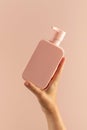 A mock-up of a pink dispenser with cosmetics in a woman& x27;s hand. A dispenser with shampoo or shower gel Royalty Free Stock Photo