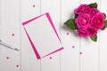 Mock-up with pink roses and small paper hearts on the white wooden table, top view Royalty Free Stock Photo