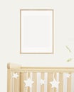 Mock up poster frame in children room, nursery room with wooden crib for kids with white ceramic stars, white wall Royalty Free Stock Photo