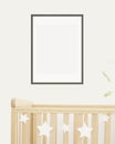 Mock up poster frame in children room, nursery room with wooden crib for kids with white ceramic stars, white wall Royalty Free Stock Photo