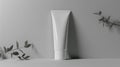 A mock up of realistic white blank cosmetic tube on white and grey background with leafs of plants Royalty Free Stock Photo