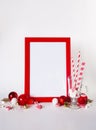 Mock up red frame on a white background with Christmas decorations and candys. Place for text, Invitation, greeting card, paper. Royalty Free Stock Photo