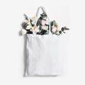 Mock-up scene of blank shopping canvas tote bag with pink tulips, daffodils flowers and eucalyptus isolated on white Royalty Free Stock Photo