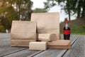 Mock up set of craft boxes and packages for packaging and delivery of food with a bottle of soda on a nature background