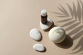 Mock up spa aromatherapy composition with bath bomb, essential oil bottle and pebbles on beige background.