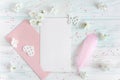 Mock up with spring cherry flowers on a light wooden background. A letter with a pink envelope and a pen with a place