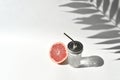 Mock up summer still life vacation scene. Cocktail glass and cut grapefruit on white background