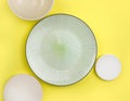 Mock up table setting on yellow background. Group of trendy ceramic utensil with plate, bowl and sauser for summer serving or rest