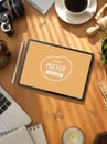 Mock up tablet on working table with office supplies, coffee cup and stationeries Royalty Free Stock Photo