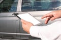 Mock up technology. Businessman in a white shirt holds a tablet with a white screen on the background of a minibus