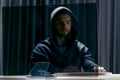 Mock-up template. Hacker in black hood and computer trying to carry out a cyberattack over the internet Royalty Free Stock Photo