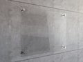 Mock Up of Transparent glass signboard with steel connectors on concrete wall