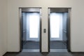 Mock up. Two empty elevators with opened metallic cabins doors and vertical poster media template frames hanging on Royalty Free Stock Photo