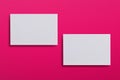 Mock up of two horizontal white business cards at pink textured paper background. Mock-up template for branding identity