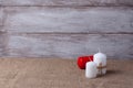 mock up of two white candles in jute rope and a red candle, cones on a wooden background