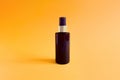 Mock-up of unbranded brown plastic spray bottle on a textured bright orange background. Cosmetic bottle container for branding