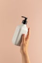 A mock-up of a white dispenser with cosmetics in a woman's hand. A dispenser with shampoo or shower gel Royalty Free Stock Photo
