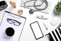 Mock up of white doctors desk with stethoscope, keyboard, mouse, glass, xray film and blank screen smart phone.Top view with copy Royalty Free Stock Photo