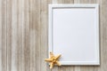 Mock up with white frame and star fish on a rustic wooden backgro Royalty Free Stock Photo