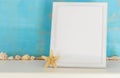 Mock up with white frame and star fish and sea shells on a turquo Royalty Free Stock Photo