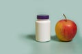 Mock up. A white plastic jar with a purple lid and apple Royalty Free Stock Photo