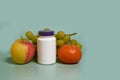 Mock up. A white plastic jar with a purple lid and apple, mandarine and grapes Royalty Free Stock Photo