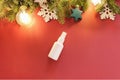 Mock-up of white plastic spray bottle, Christmas fir tree and Christmas decorations on a red background. Top view, flat lay style Royalty Free Stock Photo