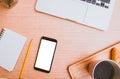 Mock up white screen on black mobile phone with note paper yellow pencil digital laptop and cup of coffee, croissant on wood. Royalty Free Stock Photo