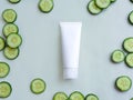 Mock-up of white squeeze cosmetic tube and fresh cucumber slices on pale green background. Top view. Moisturizing cosmetics Royalty Free Stock Photo