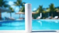 A mock-up of a tube of sunscreen stands near the pool with sun loungers