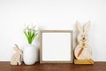 Mock up wood frame with rustic Easter decor on a wood shelf