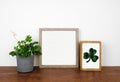Mock up wood frame with St Patricks Day decor on a wood shelf against a white wall Royalty Free Stock Photo