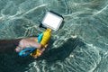 Mockup action camera in the hand of a guy submerged in the water of the pool