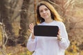 Mockup with a beautiful young brunette girl in a white sweater holding a black sign with space for text. A woman in the Royalty Free Stock Photo