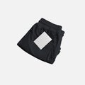 Mockup of black folded shorts with compression lining, price tag near pocket, front view
