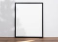 Mockup black frame with light and shadow tree on wood table. empty white frame Royalty Free Stock Photo