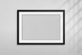 Mockup black frame photo. Shadow on wall. Mock up artwork picture framed. Horizontal boarder. Empty board a4 photoframe. Modern st