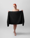 Mockup of a black towel, a girl holds in her hands horizontally, a bath towelette for branding, design Royalty Free Stock Photo