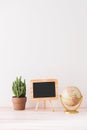 Mockup blackboard frame, globe, cactus on well arranged desk Royalty Free Stock Photo