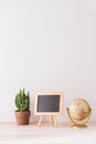 Mockup blackboard frame, globe, cactus on well arranged desk Royalty Free Stock Photo