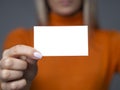 Mockup blank business card in female hands with selective focus on a card, dark gray background Royalty Free Stock Photo