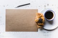 Mockup blank craft sheet of blank craft paper, pen, and morning coffee cup with croissant on white wooden desk . Minimal Royalty Free Stock Photo