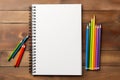 Mockup. Blank open notebook with blank sheets with colored pencils on a wooden background. Top view. Flat lay. With copy Royalty Free Stock Photo