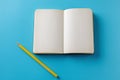 Mockup Blank page with yellow pencil. Top view with copy space for input the text. Flat lay, colored blue background. Royalty Free Stock Photo