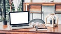 Mockup blank screen laptop at coffee shop with notebook on wood table with blur background.modern cafe lifestyle Royalty Free Stock Photo