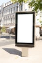 Mockup of blank white city outdoor advertising vertical billboard stand in old town street Royalty Free Stock Photo