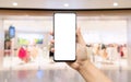 Mockup blank white screen mobile phone. Hand holding smartphone wirh blurred clothing store background for your text or Royalty Free Stock Photo