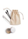 Mockup burlap bag for cosmetics, brushes for combing eyebrows, cream in jar and spray in bottle Royalty Free Stock Photo