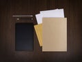 Mockup business brand template on dark wooden background. Set of stationery with digital tablet, recycled folder, paper Royalty Free Stock Photo