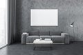 Mockup canvas above grey sofa in living room near window and grey wall with coffee table